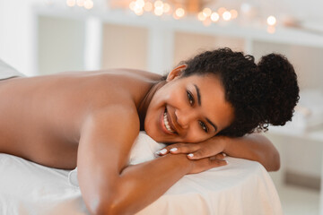 Obraz na płótnie Canvas Happy woman smiling on a spa massage table