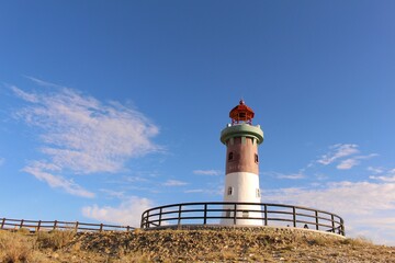 Beautiful lighthouse atop a hill overlooking the ocean - Powered by Adobe
