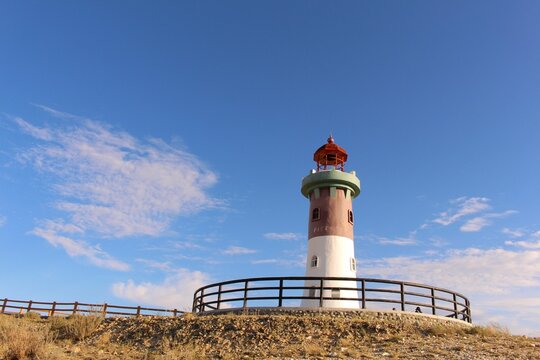 Beautiful lighthouse atop a hill overlooking the ocean