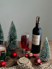 Vertical closeup shot of a glass of wine in a Christmas-themed corner