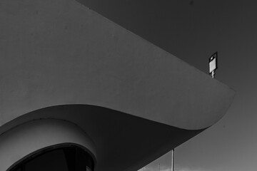 Black and white view of a console lamp behind a building during daytime