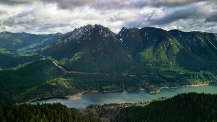 Beautiful view of the mountains and a lake under a cloudy sky in Lynn Headwaters Park in BC, Canada.