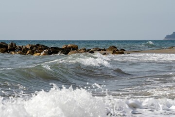 Fototapeta na wymiar Foamy waves splashing a shore line, beautiful seascape