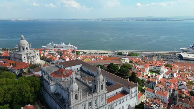 Drone shot of Alfama, the old town area of Lisbon, Portugal, with red tile roofs and the harbor