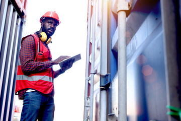 African American young engineer worker man wearing safety bright red vest and helmet, checking data...