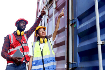 Two industrial African engineer man and woman wearing safety vest and helmet working together at...