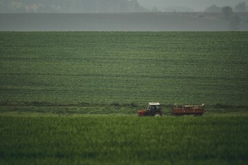 Tractor with siding harvesting in the field during a moody foggy day