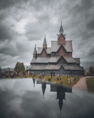 Obraz premium Heddal stave church, an old Scandinavian Viking building, and its reflection in Norway, vertical
