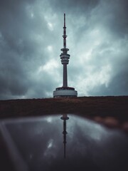 Reflection of a television transmitter on a phone screen on a cloudy day - obrazy, fototapety, plakaty