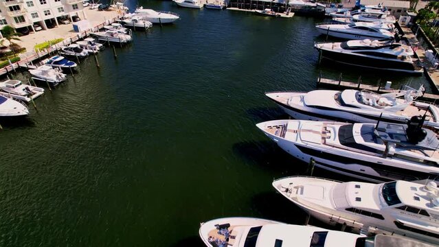Slow aerial shot of boats in the blue water blue sky palm trees ft. Lauderdale beach Florida