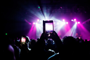 Fototapeta na wymiar Video recording of the concert on a mobile phone or a smartphone