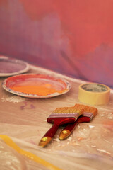 Wall painting brushes and adhesive tape on the floor, building supplies, home renovation and wall...