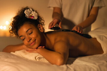 Obraz na płótnie Canvas Woman having stones massage in spa salon