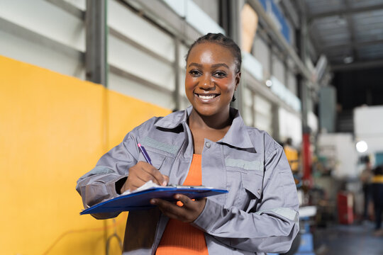 Female mechanic working at garage. Female mechanics checking car engine underneath lifted car at auto car repair service. Car service and Maintenance concept