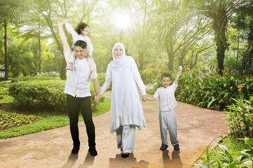 Asian muslim family having fun together at outdoor park