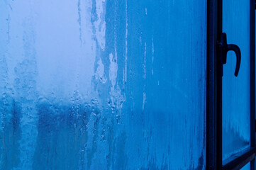 A window with a blue frosted glass and a black handle