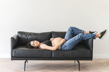Pregnant woman on black couch