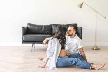 Pregnant woman sitting on floor with husband
