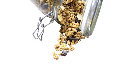 Natural muesli with chocolate falling from the open glass jar
