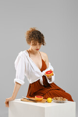 Young woman holds a ripe grapefruit in her hand