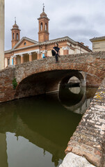 Woman on bridge in front of the cathedral San Cassiano  in Comacchio  in the province of Ferrara in the region of Emilia-Romagna in Italy