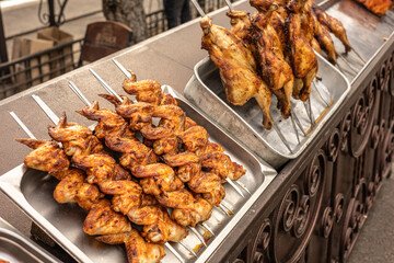 Street food stall. Roasted chicken , chicken and vegetables grilled on skewers close up