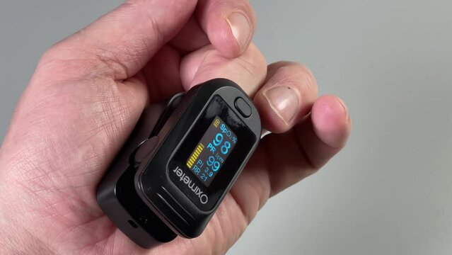 Pulse oximeter on person's finger during blood oxygen saturation measuring