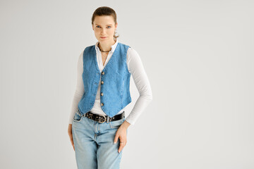 Portrait of a pretty woman dressed in denim vest and jeans