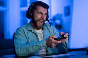 Gamer with controller feeling excitement in neon light