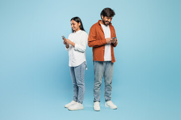 Two people focused on their smartphones on blue background