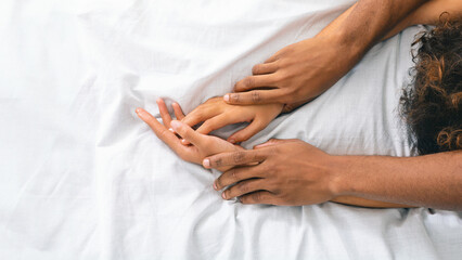 Obraz na płótnie Canvas Man and woman hands having sex on bed