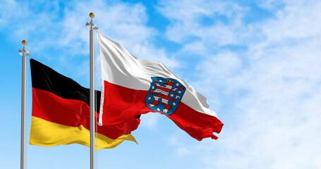 Thuringia and national german flags waving in the wind - 780508683