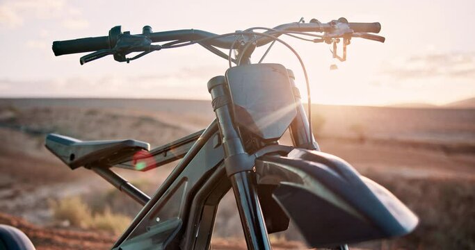 Sunset, desert and off road motorcycle for transport, adventure and machine on dune for competition. Extreme sport, mountain bike or motorbike on sand for challenge, power or race on dirt course.