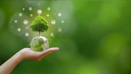 A hand is holding a globe with a tree growing on it. Several icons representing sustainability and...