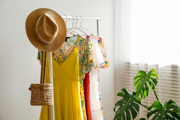Adjustable rolling garment rack with colorful dresses in a show room. Close up, copy space background.