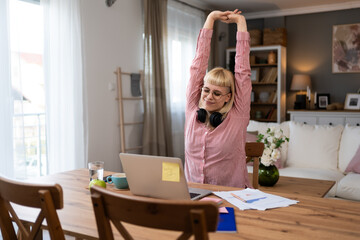 Fototapeta na wymiar Finishing work. Young beautiful blonde business woman working at home in home office, online work on laptop computer, feeling tired and exhausted after hours of telecommuting and e-business