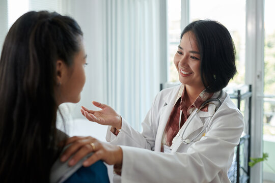 Smiling pediatrician examining teenage girl