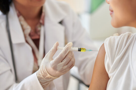 Closeup image of medical worker injecting vaccine in arm of patient