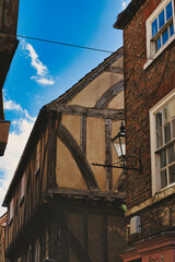 Quaint half-timbered building with exposed wooden beams under a clear blue sky, showcasing...