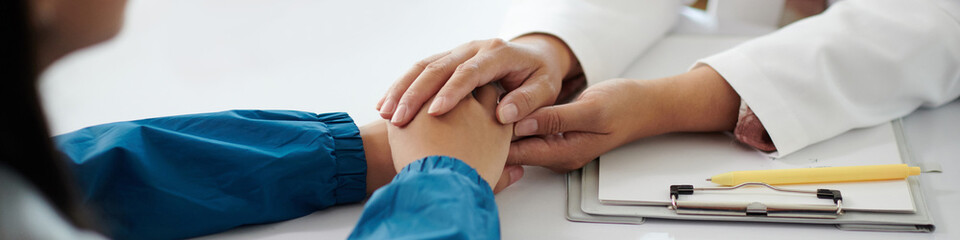 Header with doctor touching hands of sick teenage girl to reassure her