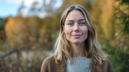 Portrait of a smiling blonde woman in Norway during autumn with a natural beauty and outdoors bokeh effect - obrazy, fototapety, plakaty