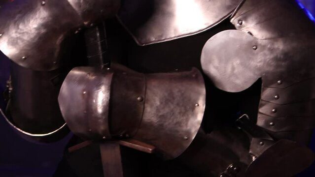 Camera movement, selective focus. Portrait of a young woman with scars on her face, dressed in black clothes, with steel knightly hands and a gorget, holding a bastard sword. Fantasy warrior girl.