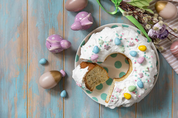 Glazed easter lemon cake decorated with confectionery and mini chocolate eggs candy on a wooden...