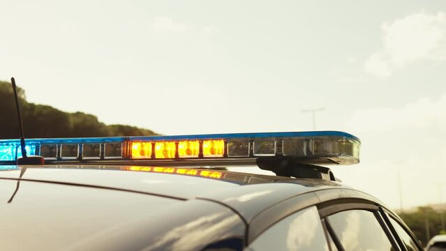 Closeup of police car light lamp blinking shining flasher police signal on crime scene under sky during daytime