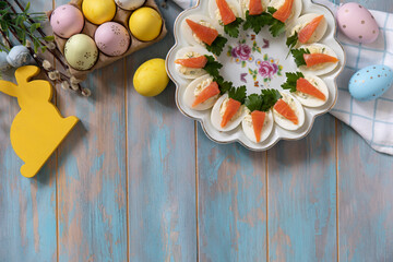 Stuffed eggs with cheese and salted salmon in the form of a carrot on a wooden table. - 780551844