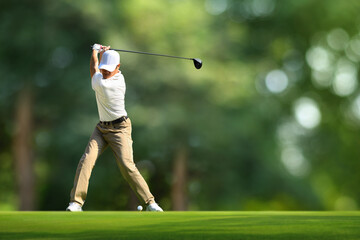 Naklejka premium Golfer driver back swing before hitting golf ball down the fairway.