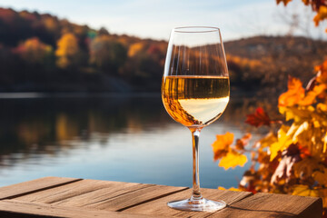 Autumnal Elegance: A Glass of White Wine Overlooking a Picturesque Fall Lake
