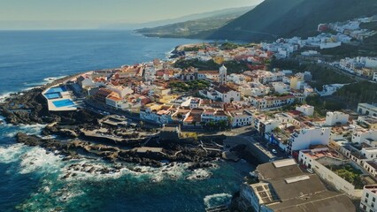 Aerial view of old town of Garachico on island of Tenerife, Canary. Flying over Garachico city center with colored houses. Ocean shore and lava pools. Popular tourist destination, Canary Islands - 780556068