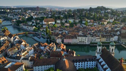 Aerial morning view of Lucerne old town and Reuss river. View of Jesuitenkirche Hl. Franz Xaver church and old houses in Luzern city center, Switzerland, shot at sunrise - 780556266