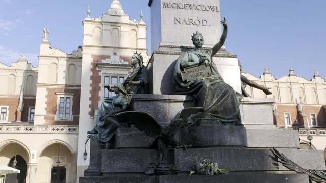 Camera tilts up the Adam Mickiewicz Monument in Rynek Glowny, Main Square in Krakow